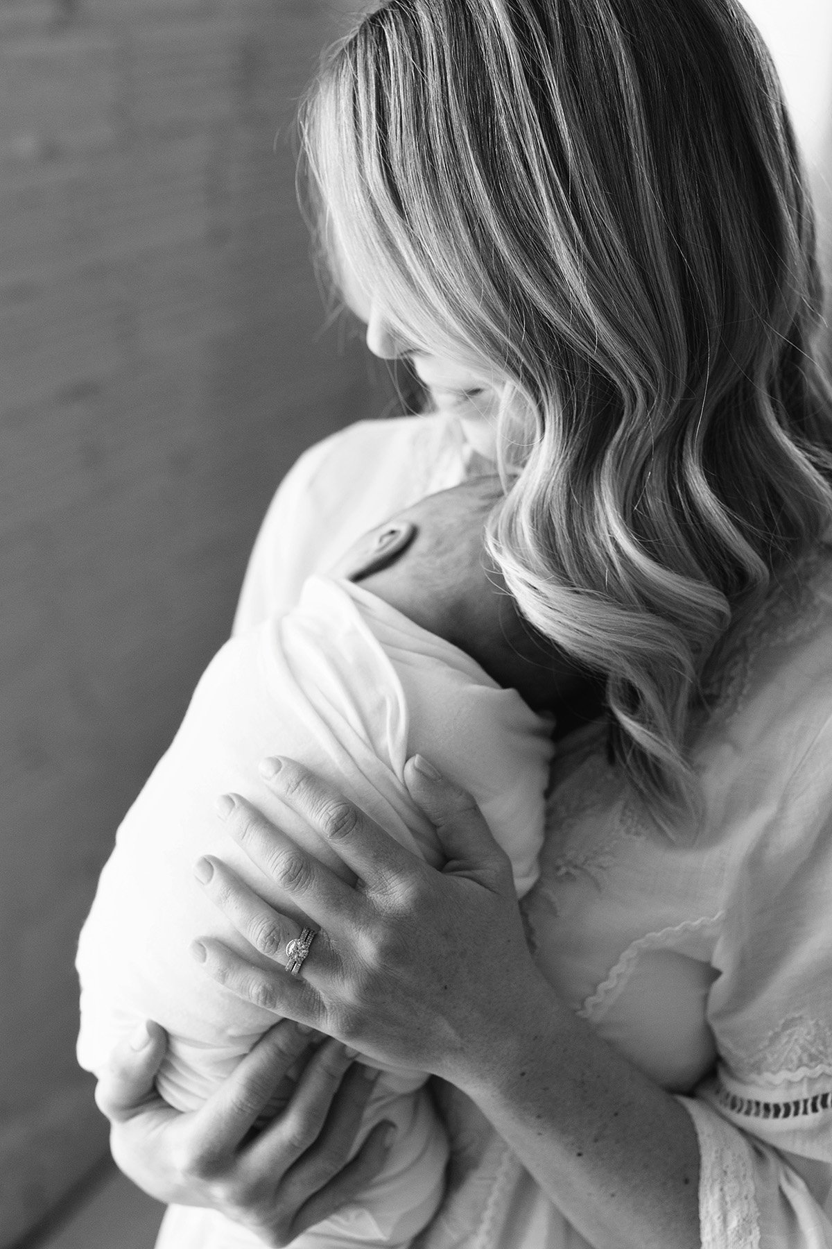 black and white photo of mom holding sleeping baby boy at louisville ky photography studio