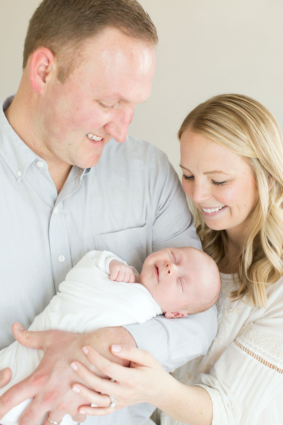 Baby smiles while parents hold him at Julie Brock Photography Louisville KY