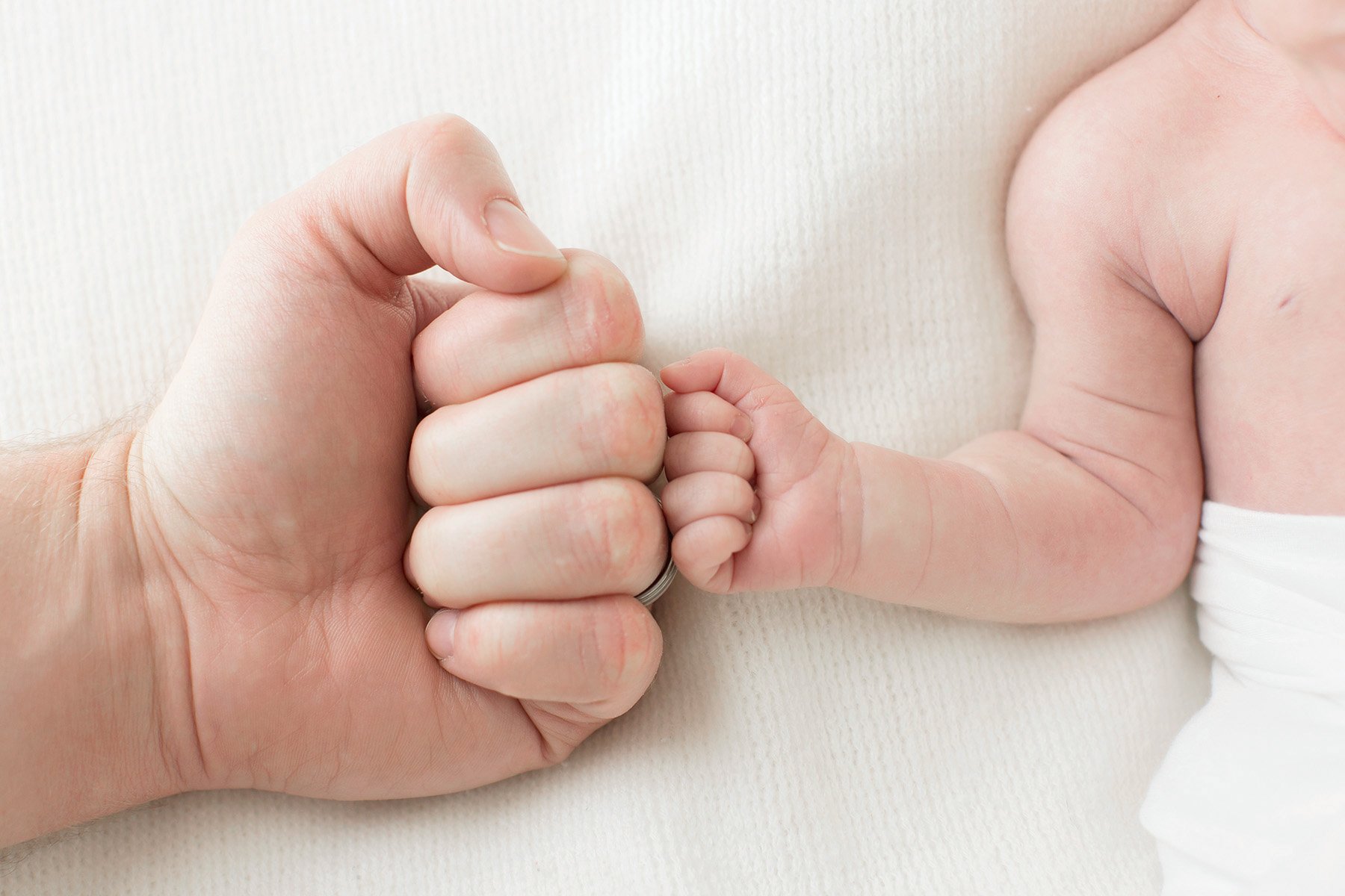 dad fist bumps newborn baby boy