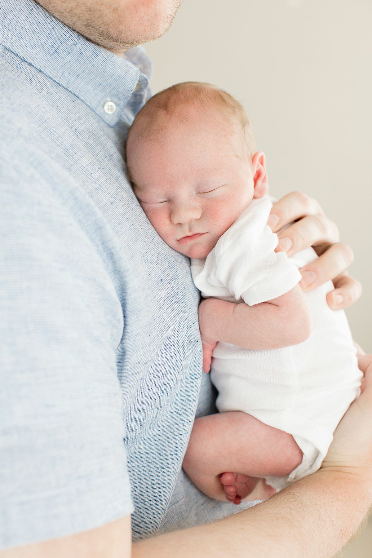 dad holds sleeping baby close to his chest during photo shoot at Julie Brock Photography in Louisville KY