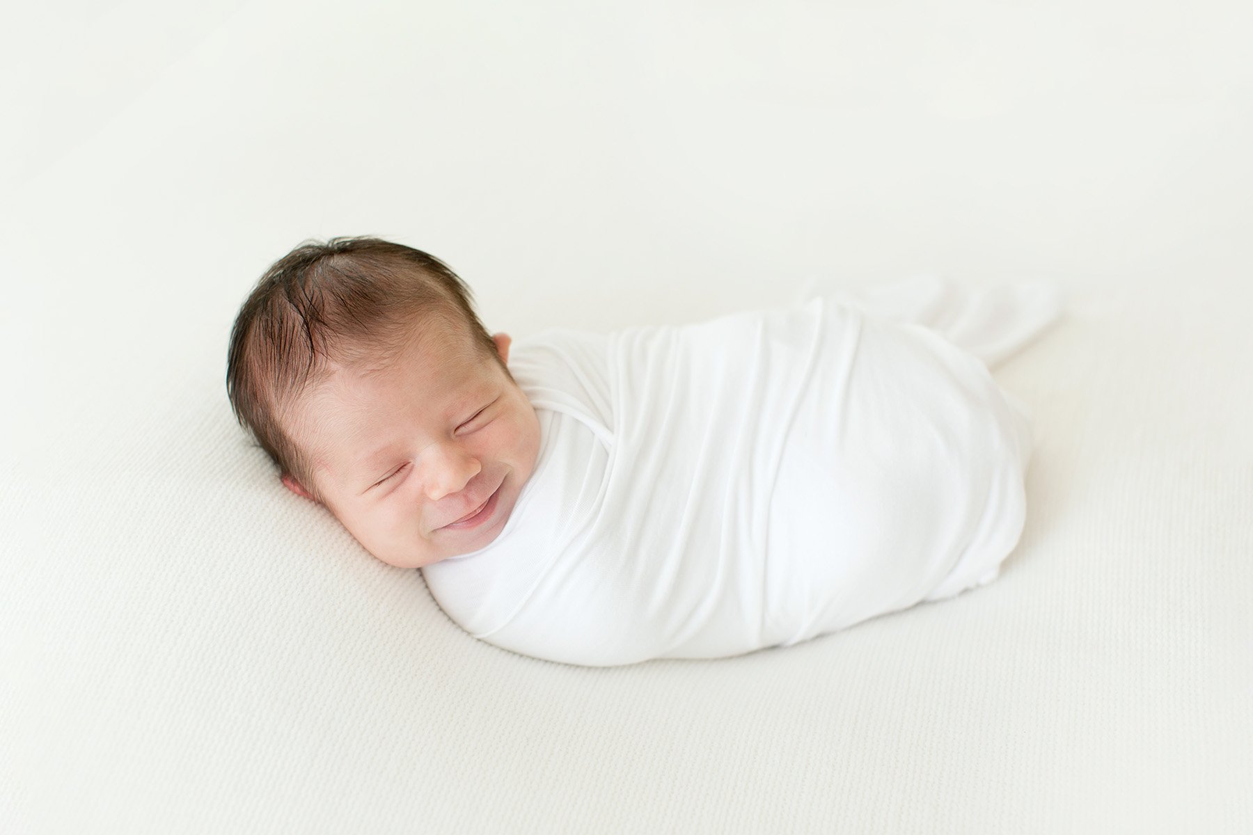 Newborn baby smiles during photo shoot with Julie Brock Photography in Louisville KY
