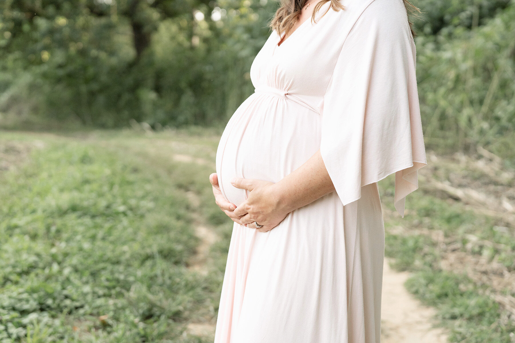 Pregnant mother wearing soft pink Rachel Pally dress during her Louisville KY outdoor photo session.