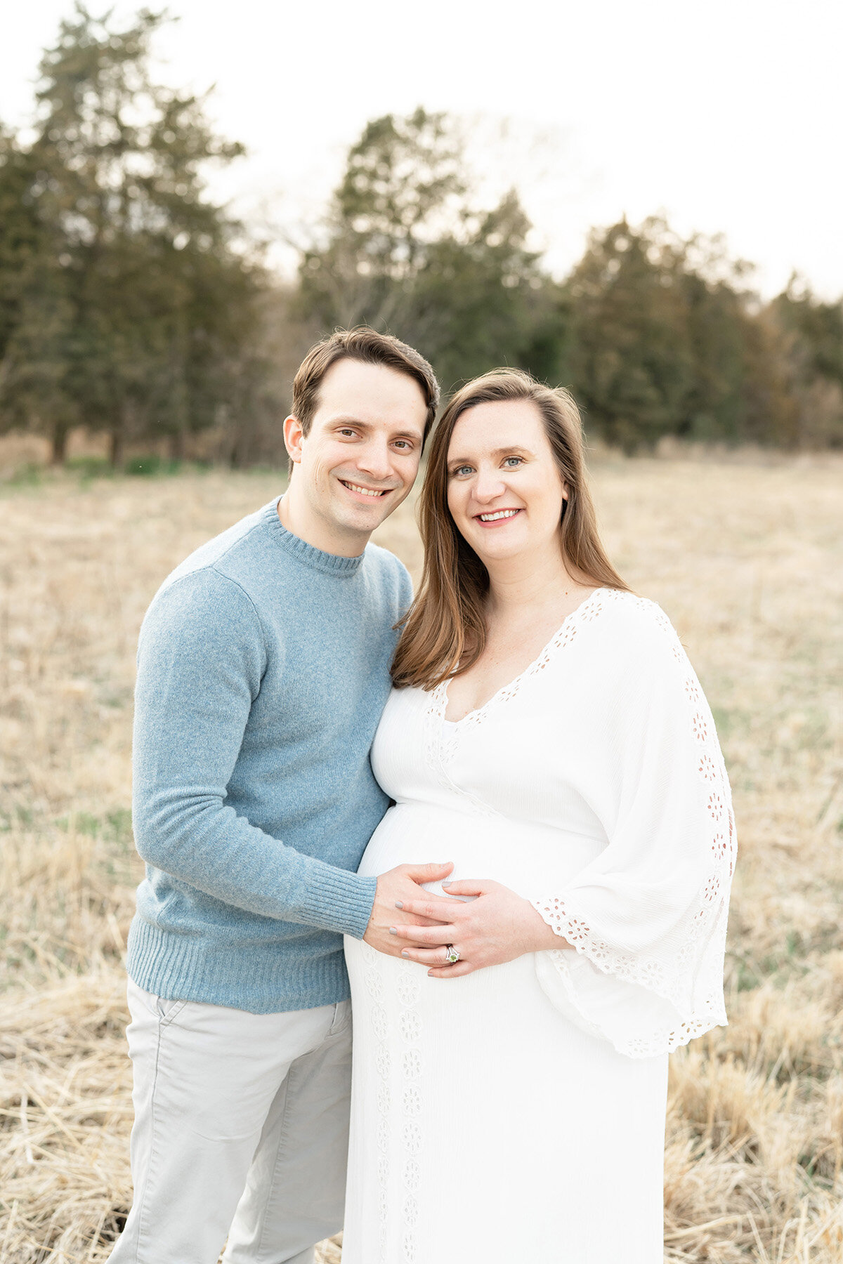 Julie Brock Photography naturally poses this smiling couple during an outdoor maternity photo session. Mother is wearing a Fillyboo dress borrowed from Julie Brock’s wardrobe for mothers.