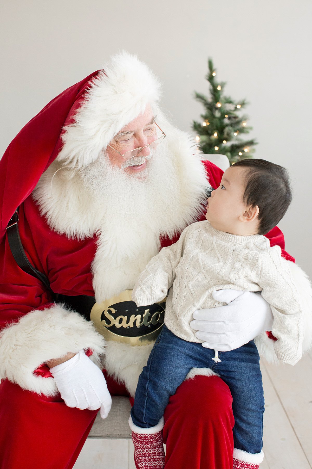 Baby boy looks curiously at Santa at Julie Brock Photography studio in Louisville KY