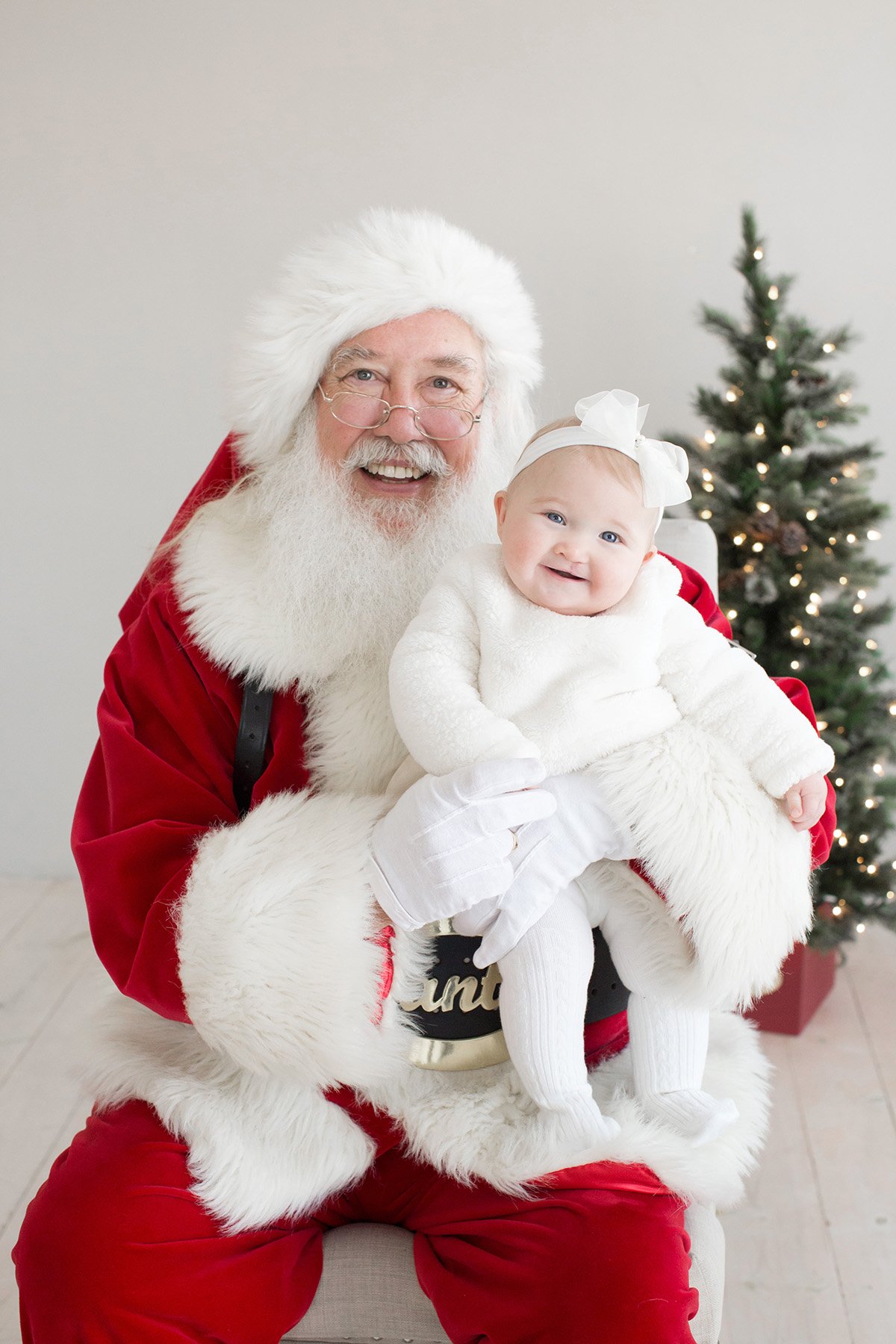 Baby girl smiles while taking picture with Santa at Louisville KY photography studio