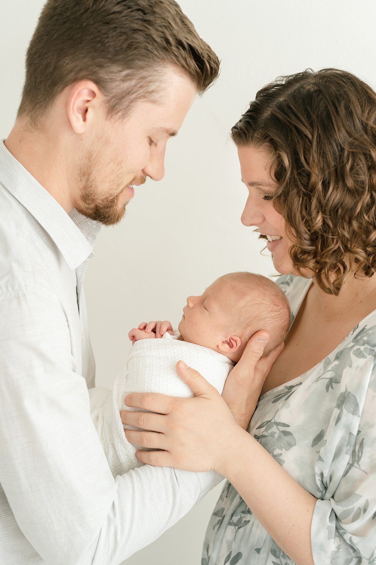 mom and dad hold newborn baby boy at Julie Brock Photography Studio in Louisville KY