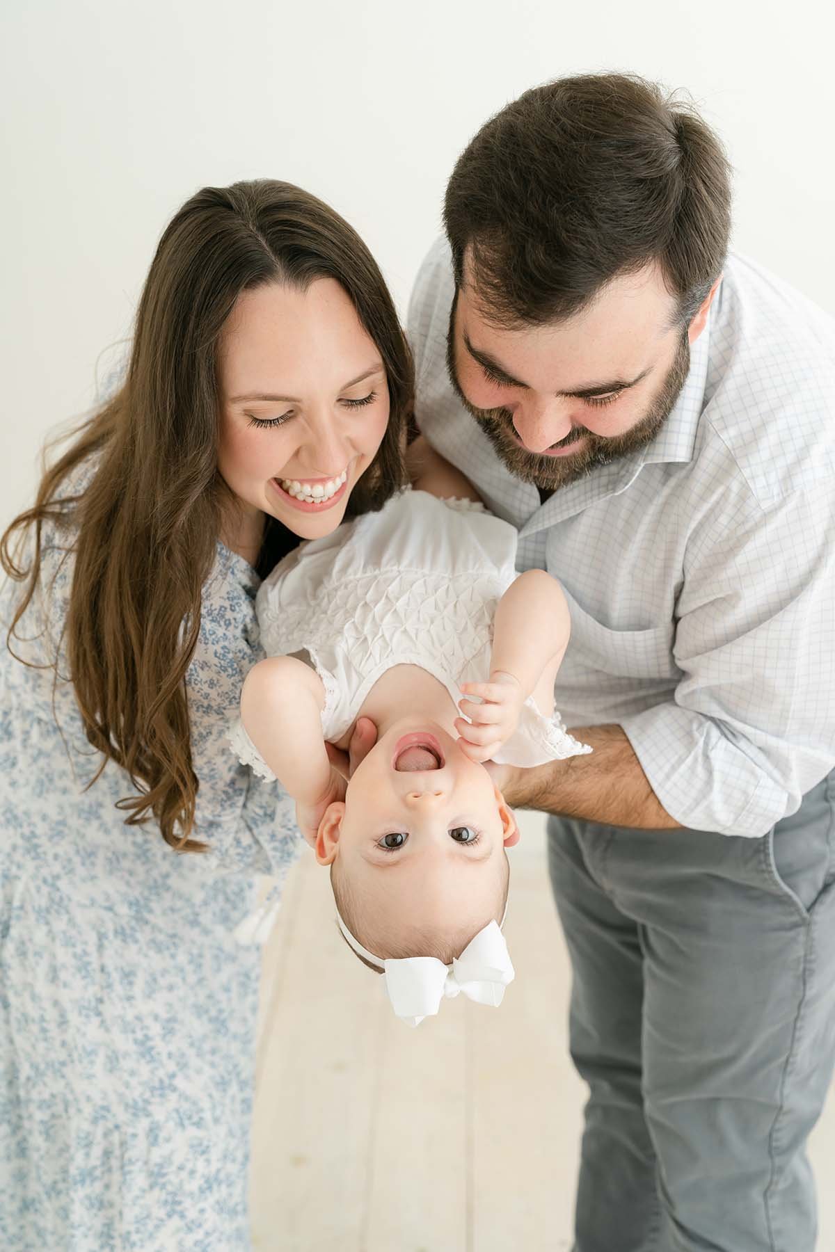 Mom and dad play with daughter during family photo shoot with Julie Brock Photography in Louisville KY