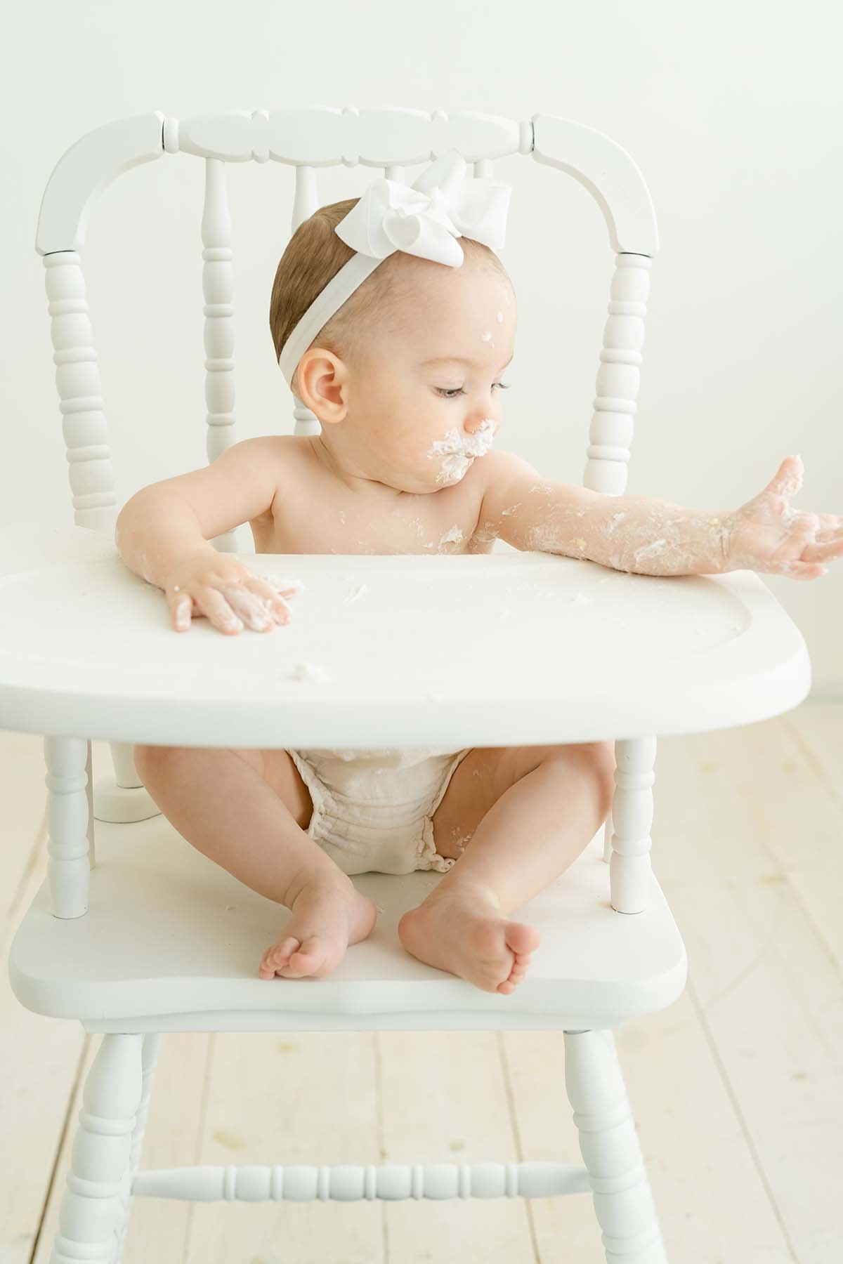 baby tosses cake during birthday cake smash photoshoot with Julie Brock in Louisville KY