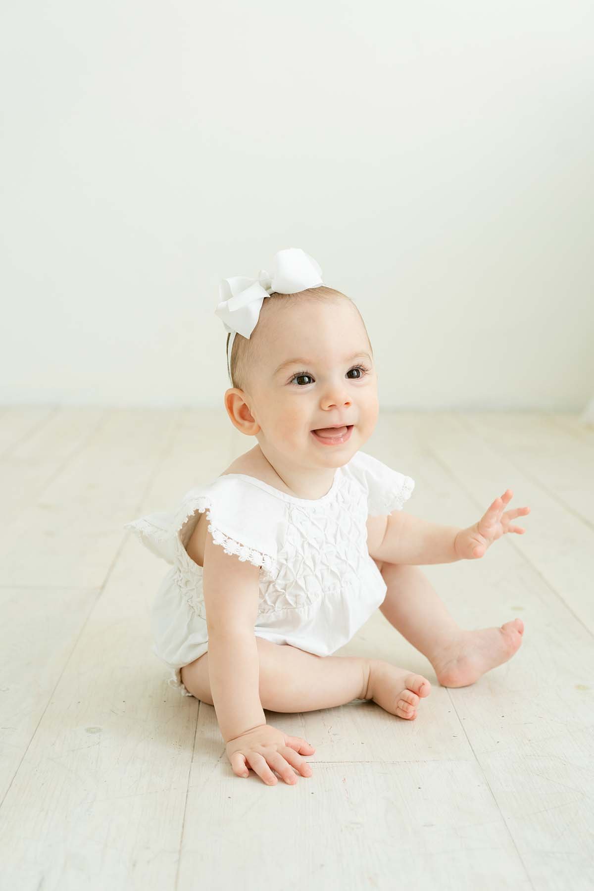 Baby girl wears ivory bubble romper during first birthday photos at Julie Brock Photography in Louisville KY