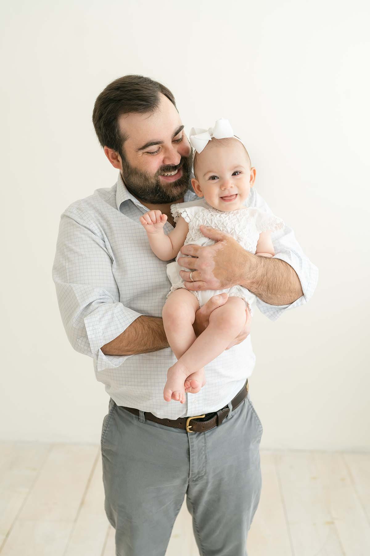 Dad laughs with one year old daughter during family photo shoot with Julie Brock in Louisville KY
