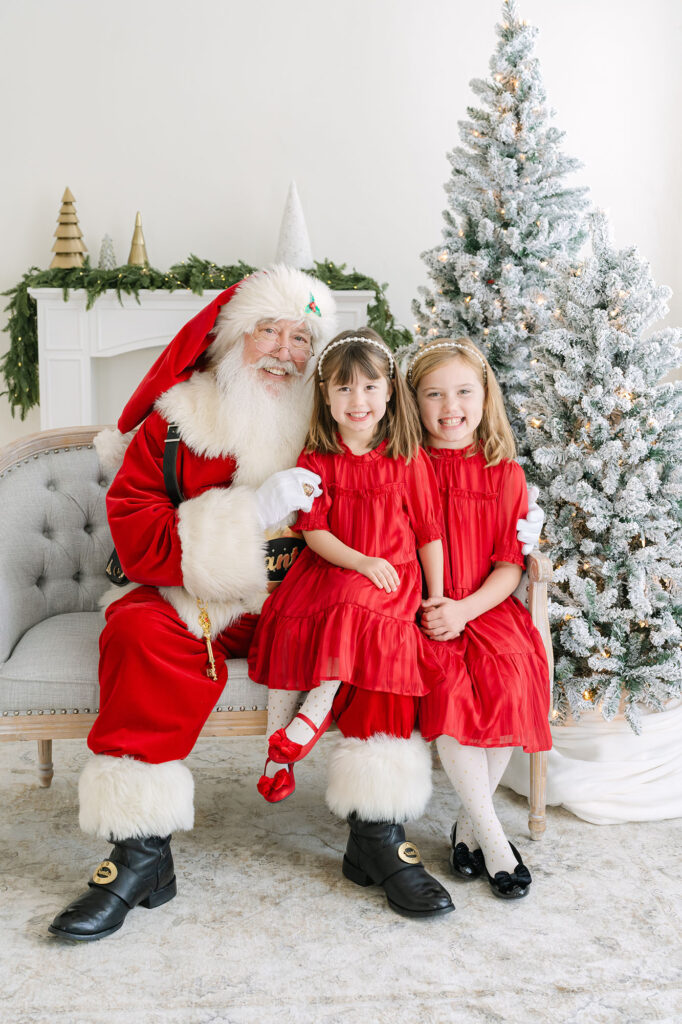 Sisters in red dresses take pictures with Santa at Julie Brock Photography in Louisville KY