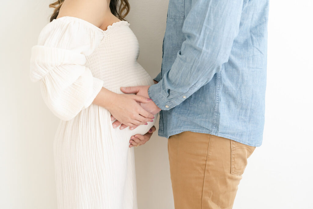 Expectant couple holds baby bump during maternity photo shoot at Julie Brock Photography in Louisville KY