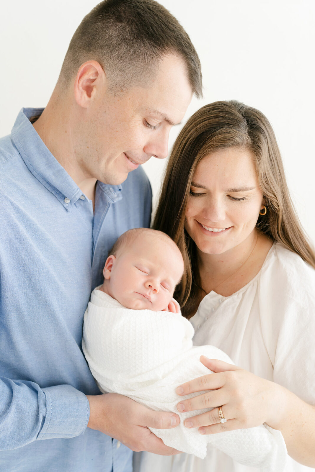 New parents hold sleeping baby boy for pictures at Julie Brock Photography in Louisville KY
