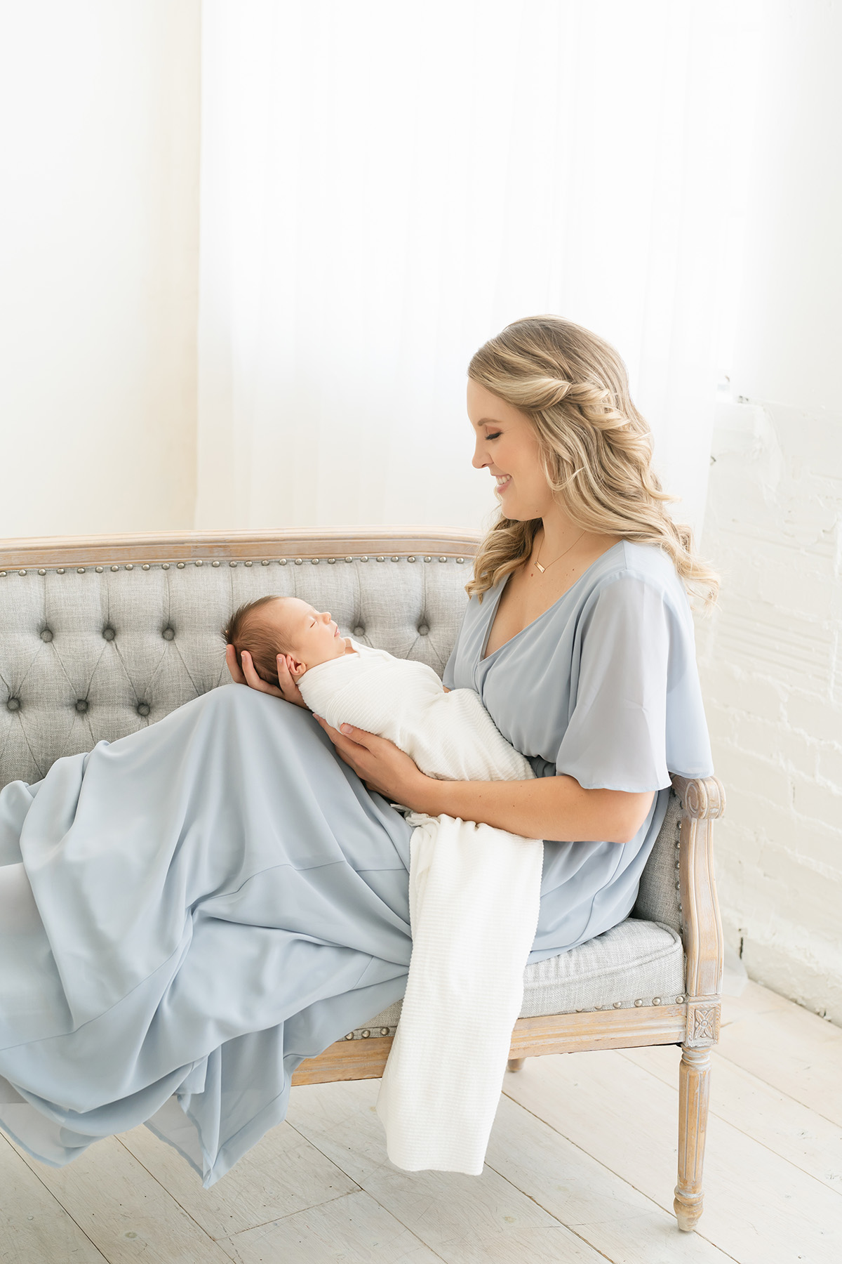 Louisville KY mother wears blue dress from Julie Brock Photography's studio wardrobe for newborn pictures
