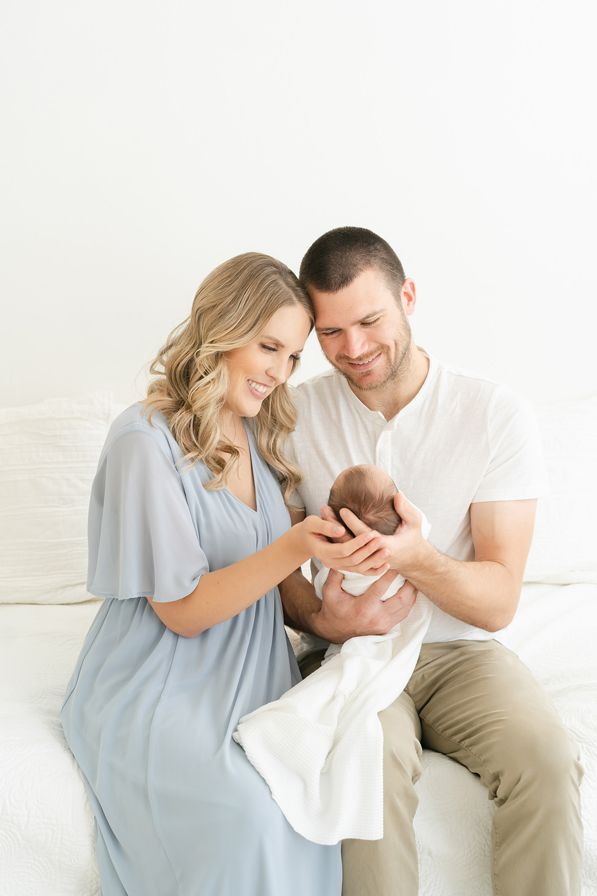 Louisville Kentucky couple smiles at their newborn baby at Julie Brock Photography in Louisville KY