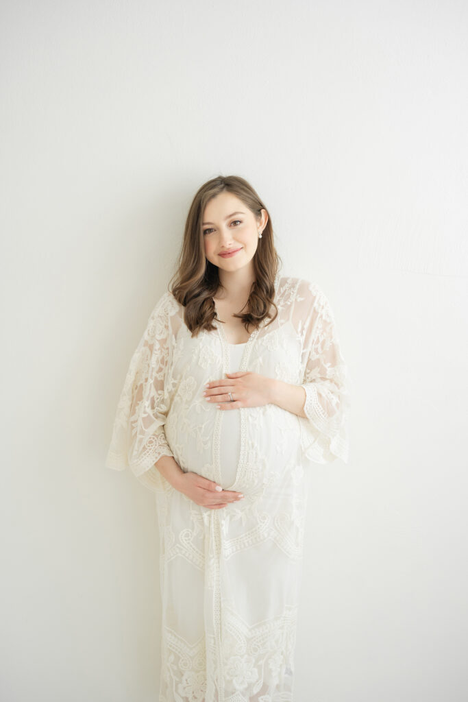 Louisville Ky mother wears lace dress during a maternity photo shoot at Julie Brock Photography.