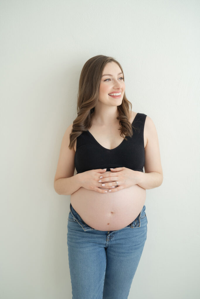 Pregnant mother wears crop top and jeans during maternity photos at Julie Brock Photography in Louisville KY