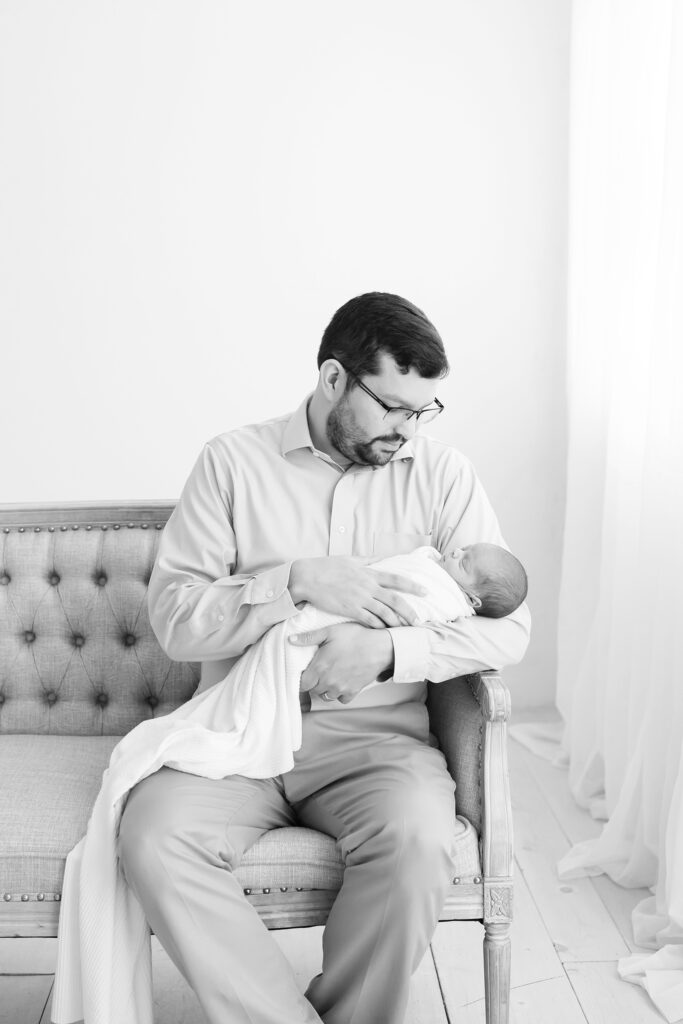Louisville father holds his newborn son during a photo shoot with Julie Brock Photography
