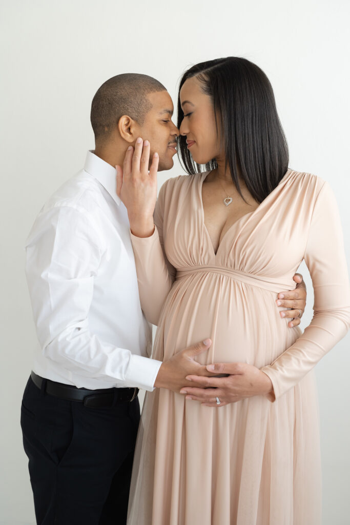 Louisville KY husband and wife smile at each other during elegant maternity photo session with Julie Brock Photography
