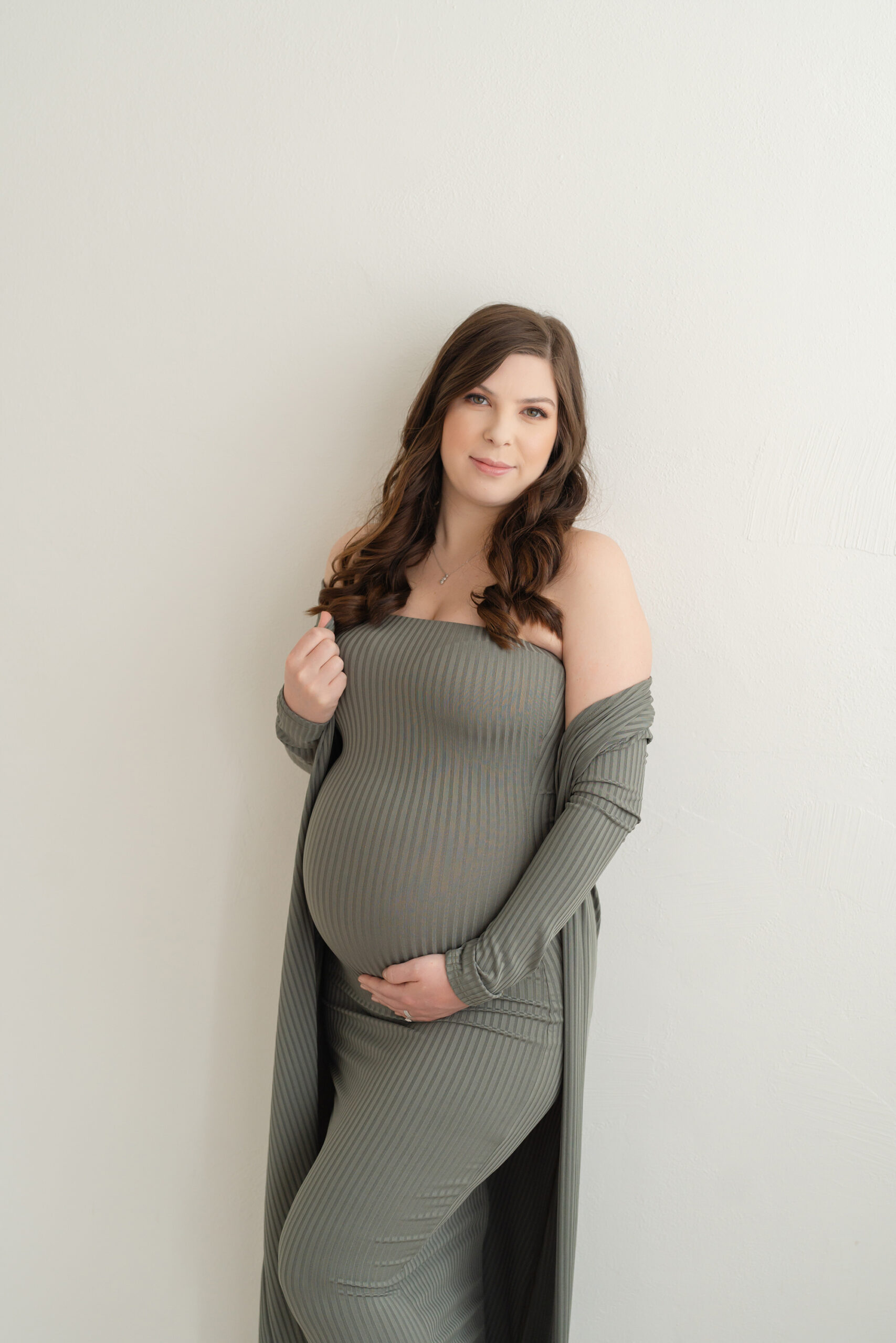 Louisville mother wears off shoulder, fitted green dress for maternity pictures at Julie Brock Photography