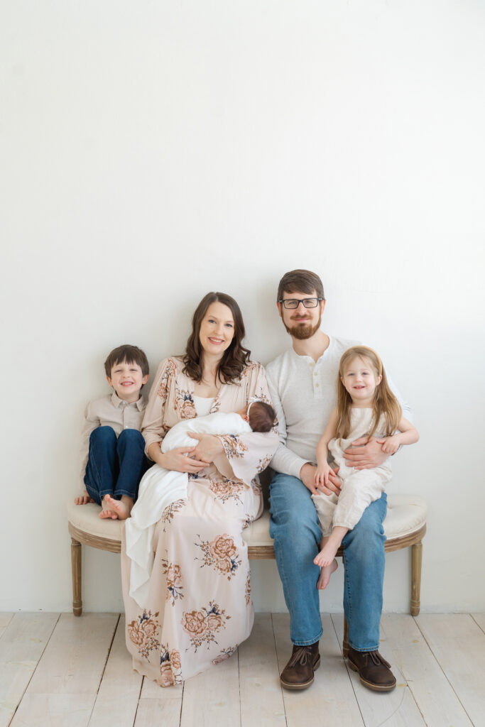 Louisville family of five pose and smile for newborn photo session with photographer Julie Brock