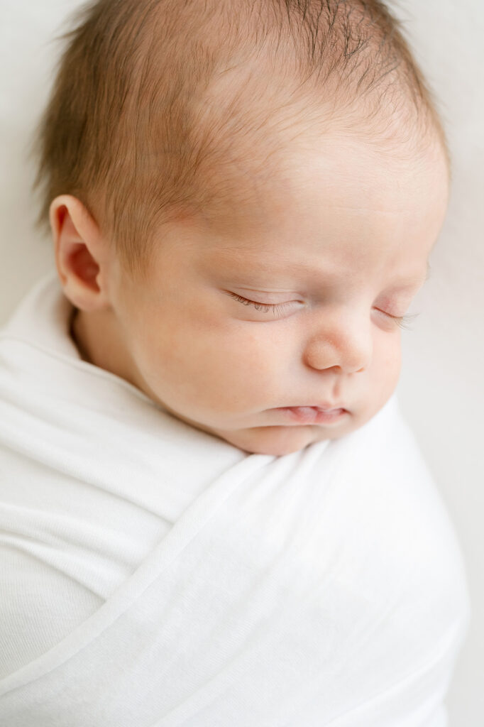 Picture of sleeping infant boy in a white knit wrap during a Newborn Photo Session at Julie Brock Photography near Louisville KY and Southern Indiana