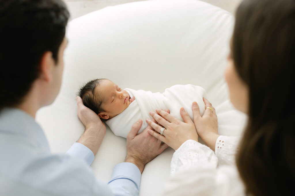 Louisville Ky Parents hold their sleepy newborn for pictures at Julie Brock Photography Studio