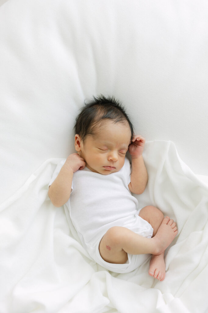 Newborn baby boy is curled up sleeping during a Louisville Newborn Photography session with Julie Brock