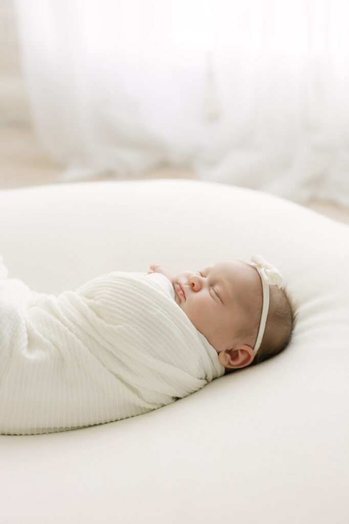 newborn baby sleeps swaddled in white blanket at Julie Brock Photography in Louisville KY