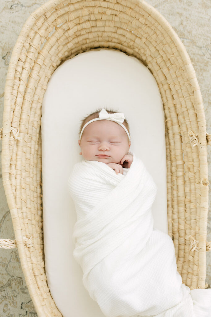 louisville newborn photographer Julie Brock places sleeping baby in basket