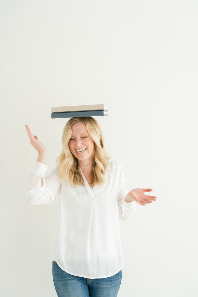 Best Newborn Photographer in Louisville KY candid images of her balancing albums on her head.