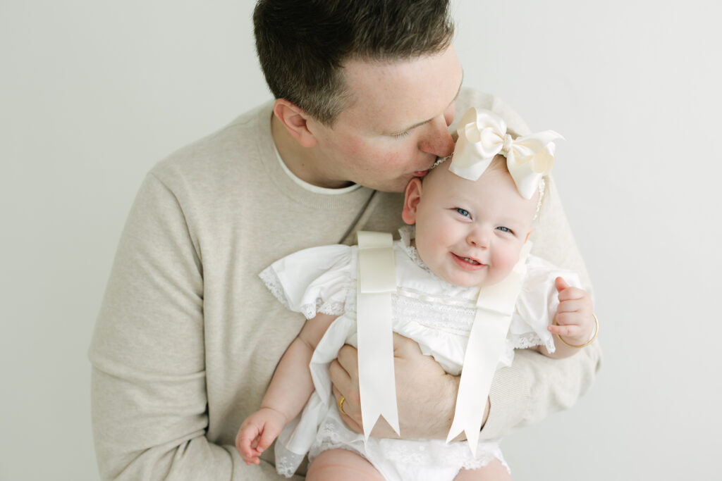 Father hugs his baby girl during their first birthday photos at Louisville Ky family photography studio