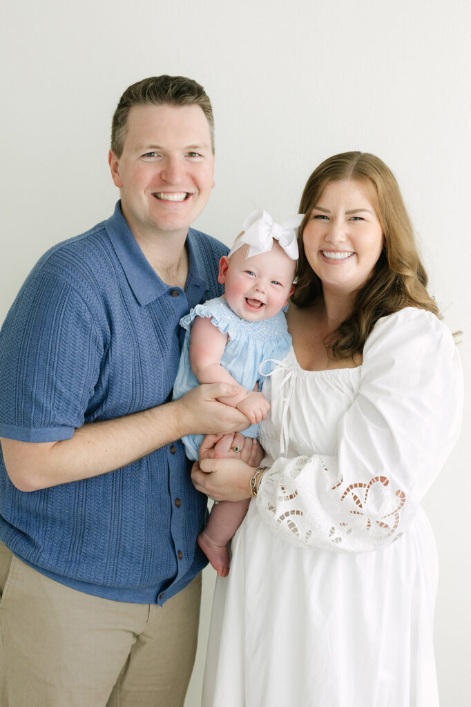 Louisville family photographer captures image of smiling baby girl with with parents at her St Matthews Kentucky photography studio