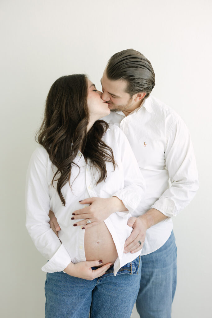 Expectant parents kiss during Maternity Family Photo Session at Louisville KY Photography Studio with Julie Brock