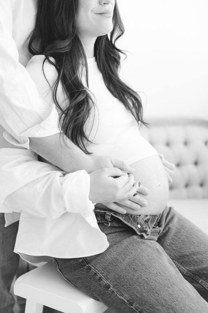 Expectant mother with broken foots sits on stool during her Maternity Session at Louisville KY Photography Studio with Julie Brock Photographer